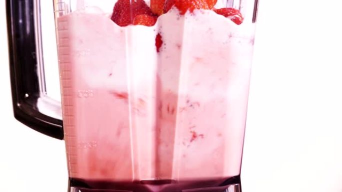 在白色4K的搅拌机中摇动草莓水果