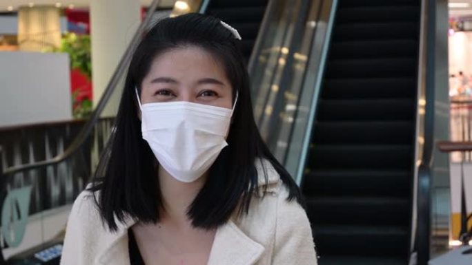 亚洲女子戴卫生口罩防护用品商场冠状病毒流行