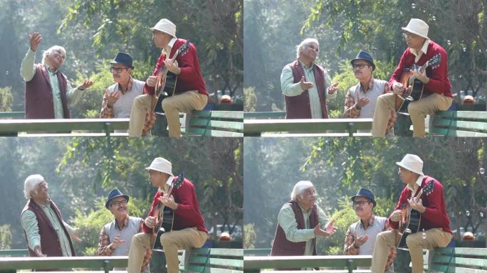 三名老人弹吉他并在公园玩得开心