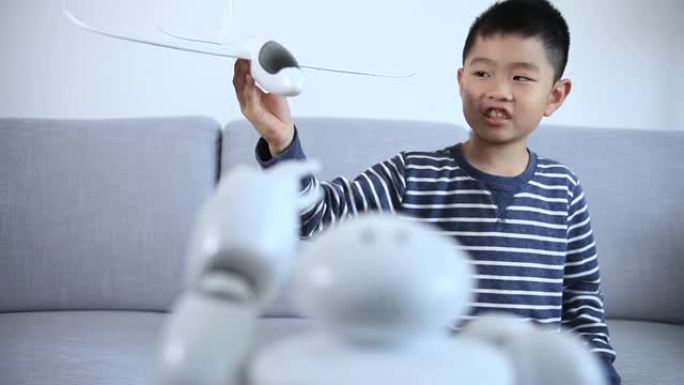 聪明的男孩向机器人介绍模型飞机