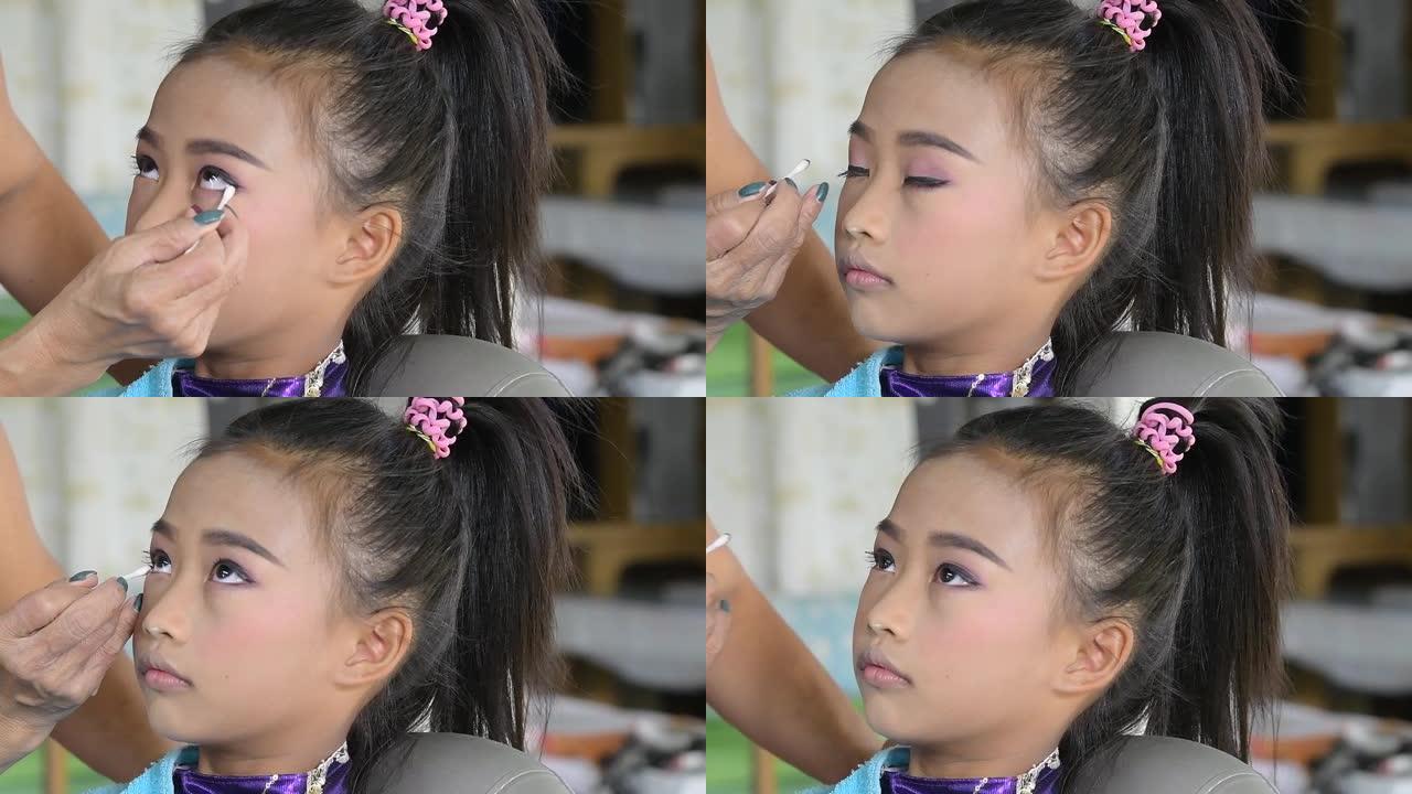 为亚洲女孩化妆的化妆师。