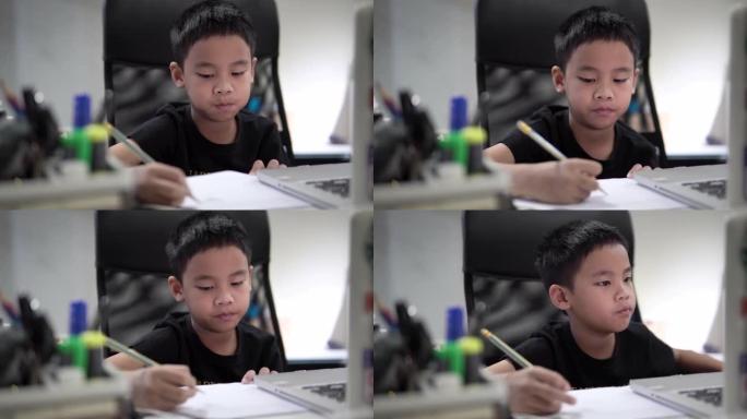 男孩学习视频在线课在隔离新型冠状病毒肺炎的家庭。