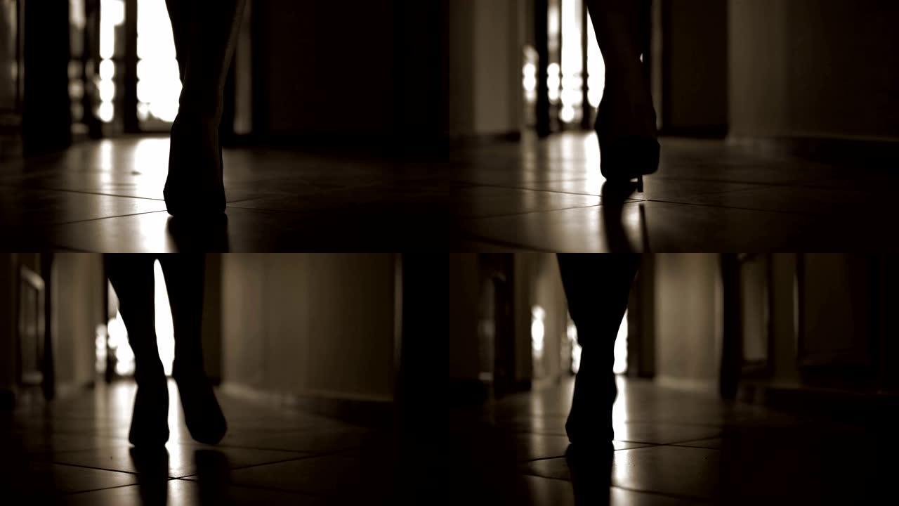 穿着高山鞋走在黑暗走廊上的时装模特女性的剪影