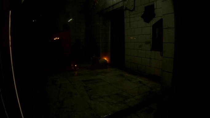 POV穿过玻璃门印度教僧侣，在寺庙的盘子上走蜡烛
