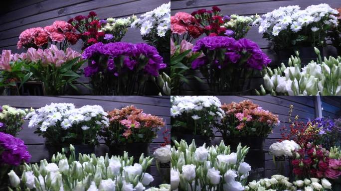 农贸市场花店入口处的一束五颜六色的玫瑰和其他鲜花。日常花卉柜台有各种鲜切花。许多美丽的鲜花花束。