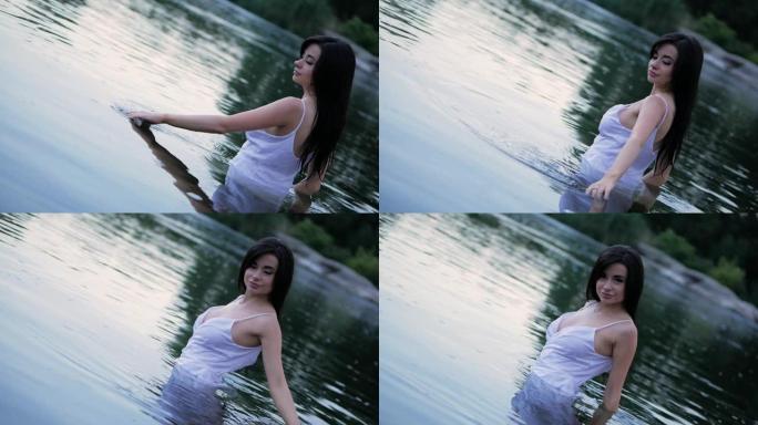 美丽的黑发女孩，长发站在湖里。慢动作。