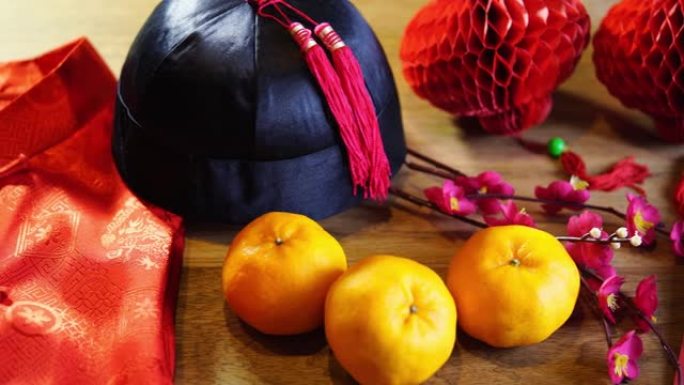 木色背景上的橘子、红灯笼和中国红包