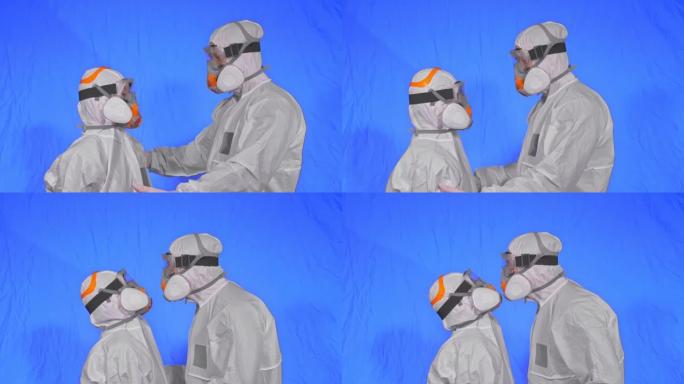 男女医生穿着防护服，气体保护医用喷漆面具。爱情情侣亲吻和拥抱，卫生工作者在呼吸器新型冠状病毒肺炎。