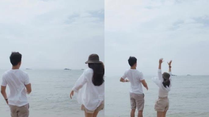 垂直视频: 恋爱中的亚洲夫妇在假期周末举起双臂庆祝成功。