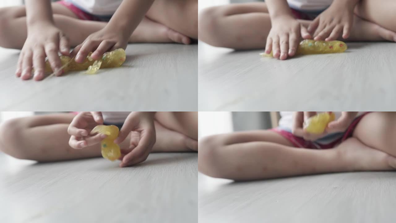 快乐的亚洲女孩一起坐在家里的地板上玩粘液或玩具粘土，生活方式的概念。