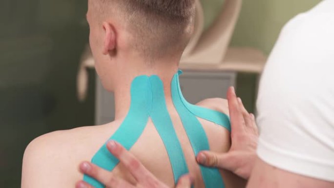 物理治疗师用胶带给病人脖子和肩膀。运动疗法。特写演示视频。颈椎治疗