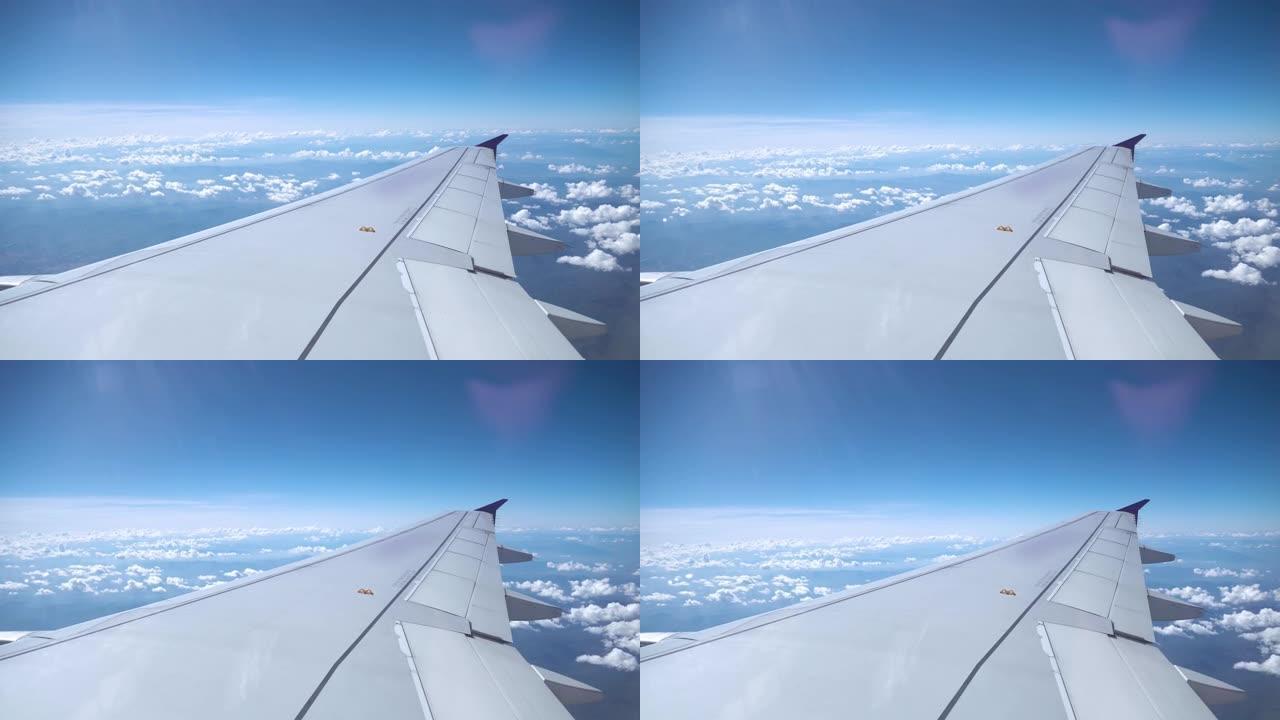 透过飞机的窗户可以看到天空和云。