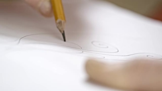 艺术家用黑色铅笔画一条平线。艺术家手画木制铅笔在纸上写线。