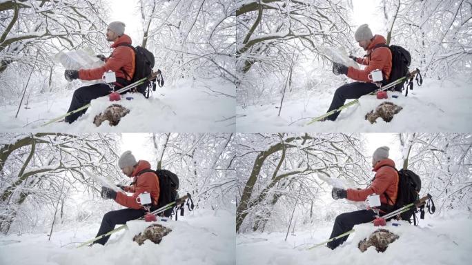 徒步旅行者在茶歇的雪山检查地图