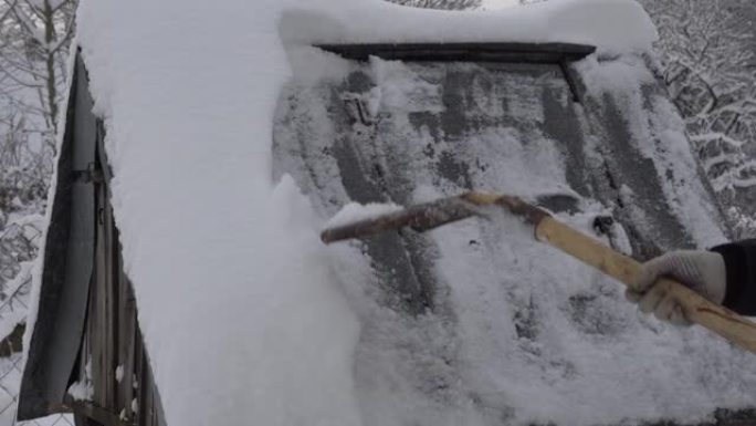 一个男人用铁锹从村里的井里清理雪，很多雪，冬天在村里