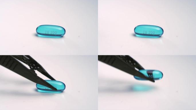 单个蓝色布洛芬液体凝胶药丸的特写镜头被白色表面上的工具捡起