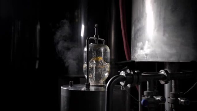 啤酒厂的水制备，水在金属桶上的玻璃瓶中沸腾并过滤