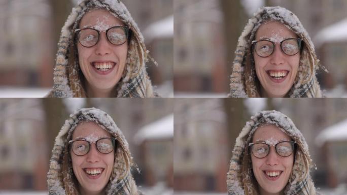 微笑而快乐的年轻女子，脸上和眼镜上有雪