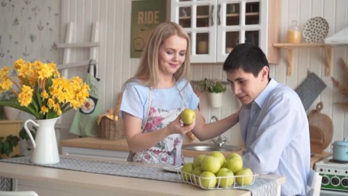 一个年轻的女人给她的男朋友一个青苹果，他们一起手里拿着一个苹果。
