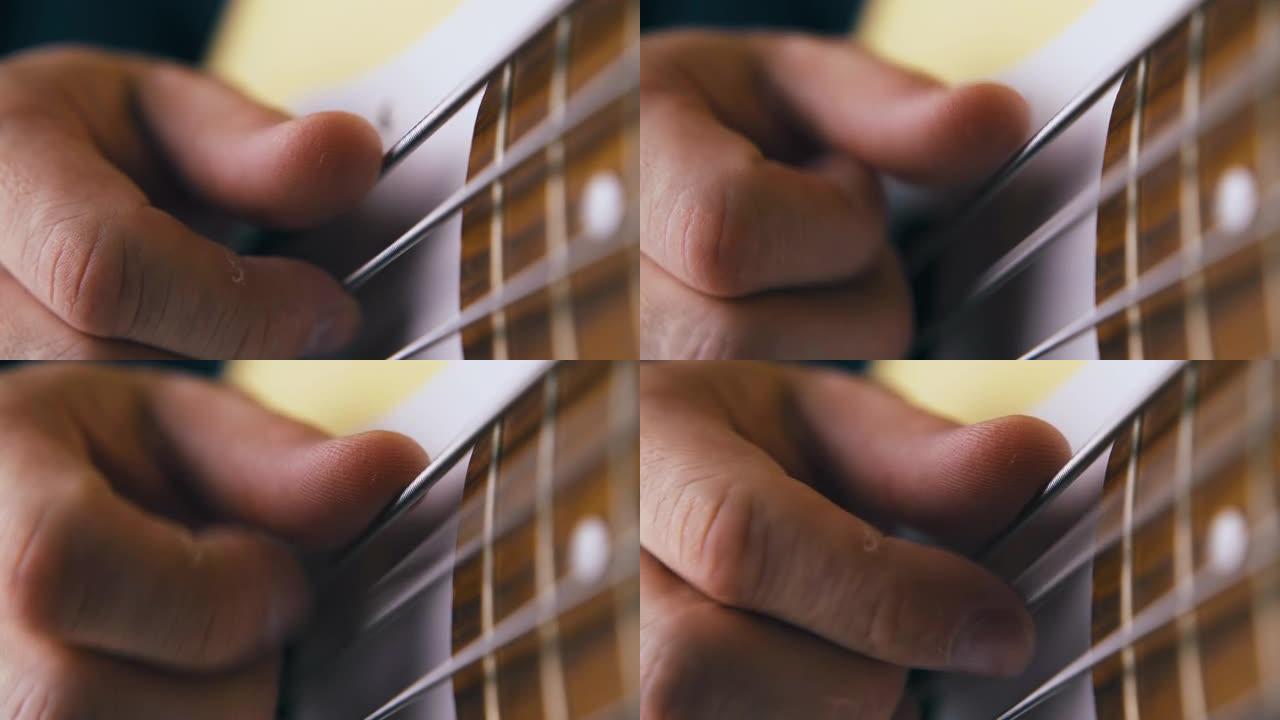 音乐家用金属弦特写演奏白色低音吉他