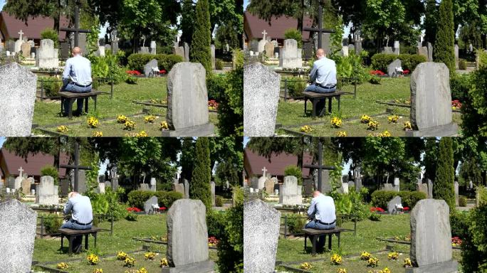 哀悼丈夫的男人坐在墓地妻子坟墓附近的长凳上。4K
