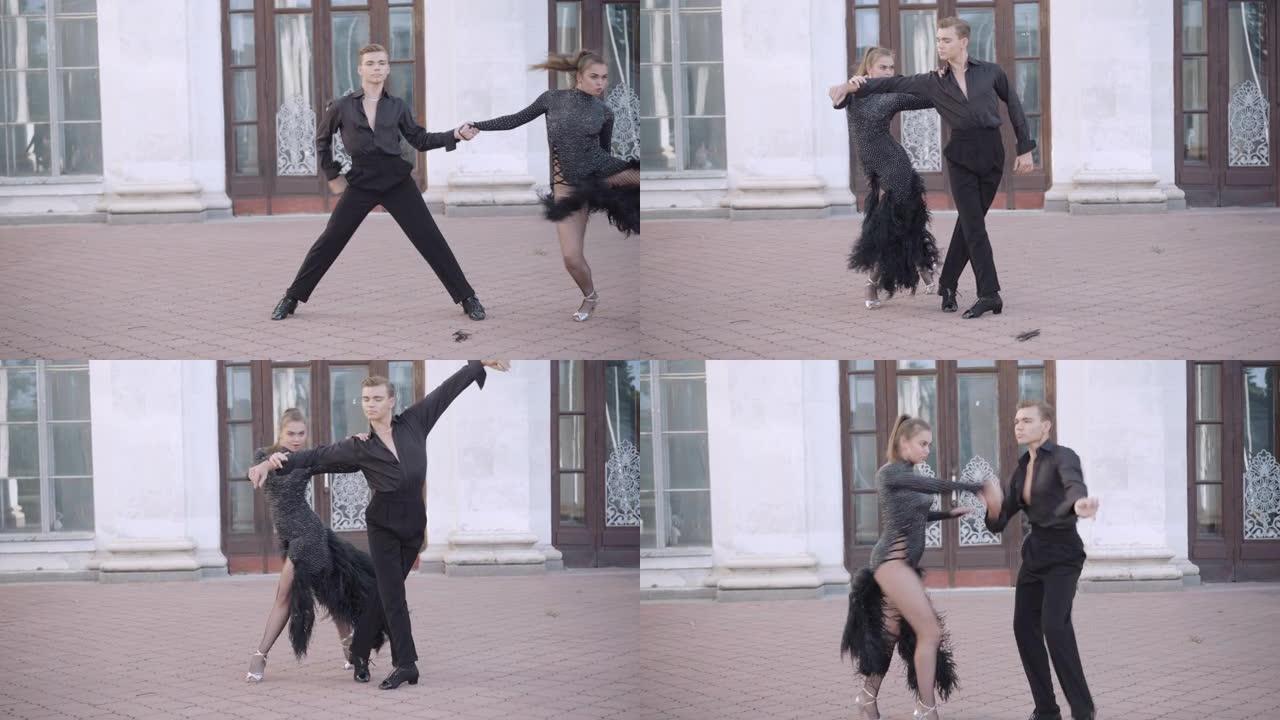 自信的夫妇在城市表演帕索多布尔的镜头。熟练的才华横溢的年轻高加索芭蕾舞演员在户外跳舞的肖像。拉丁交际