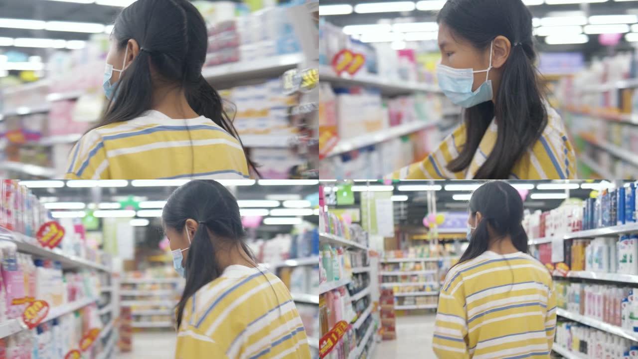 亚洲女孩戴着口罩，在新型冠状病毒肺炎前为家庭囤积食物，生活方式概念。