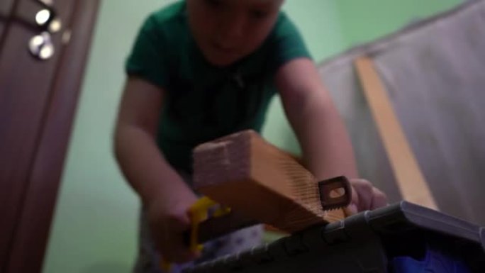一个孩子正在用钢锯锯木板。