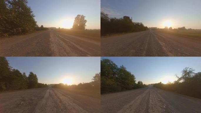夏季日出时，汽车在风景秀丽的树木周围的道路上快速行驶。在农村公路上行驶时的视点镜头。