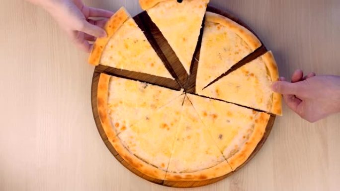人们在木板上近距离俯视图上取一片带有不同类型奶酪的玛格丽塔披萨。