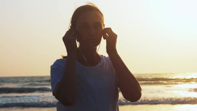 女人在海边慢跑前放耳机听音乐