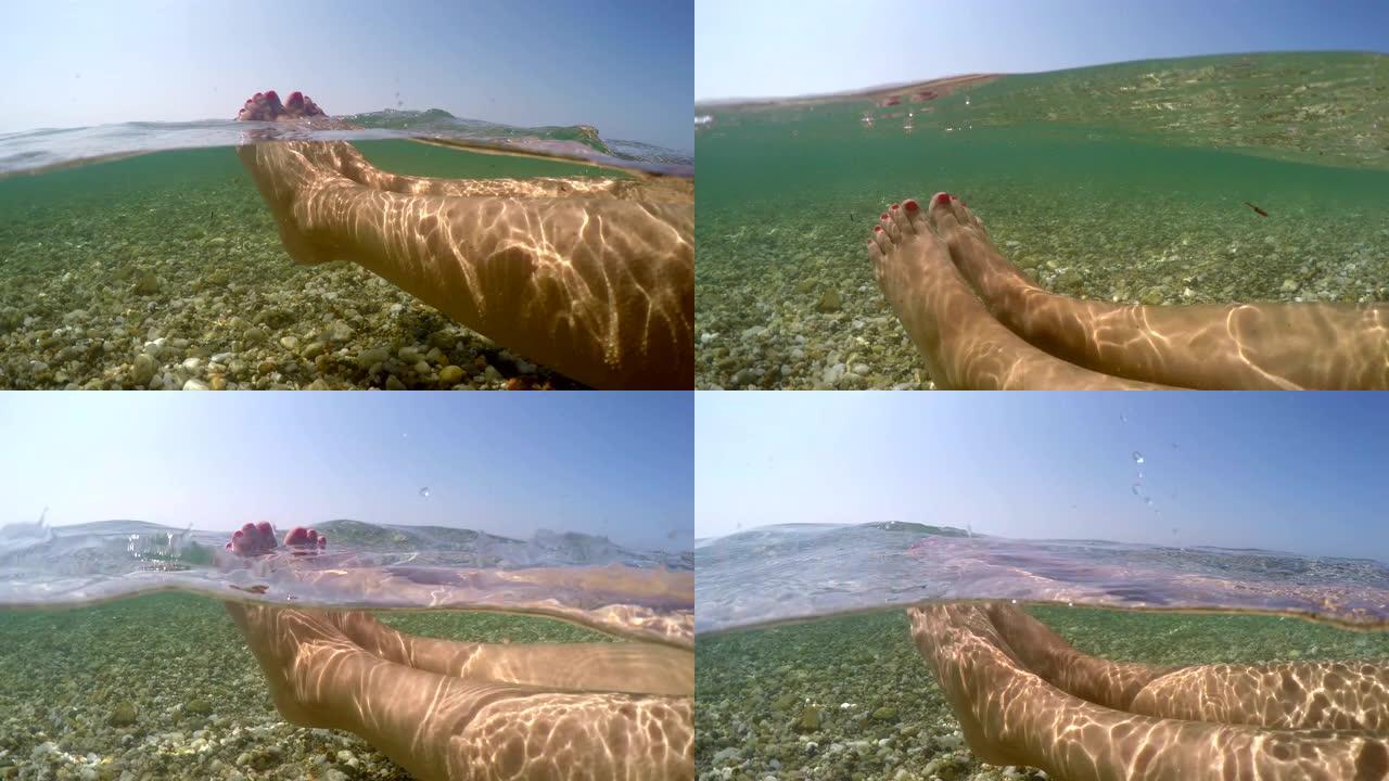 女性脚在海水浅水中放松漂浮，暑假概念，半水下视图gopro圆顶拍摄