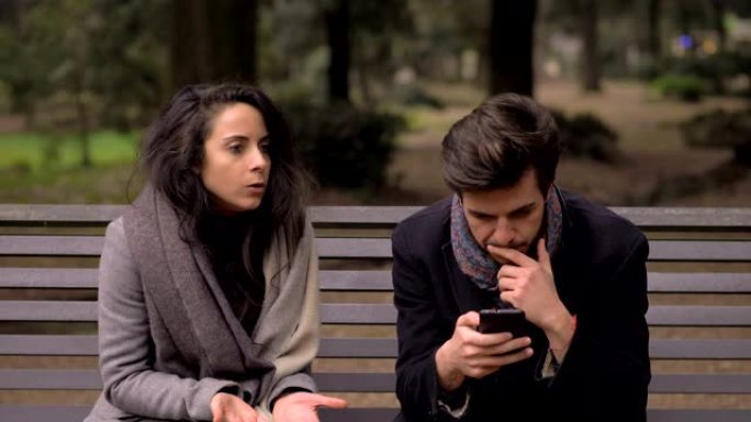 丈夫在使用智能手机时假装听女友的chat不休的肖像