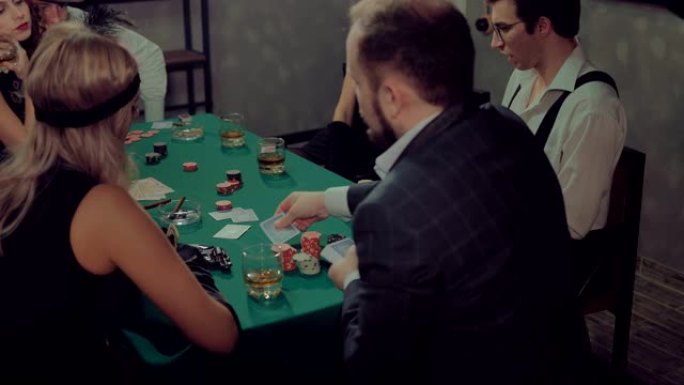 男人把牌放在桌子上，打开它们。后视图。