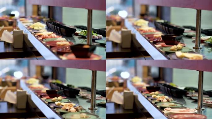 餐厅中沿皮带移动的盘子上的食物