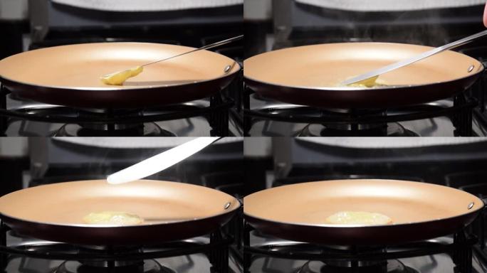 黄油被放入热煎锅中融化。