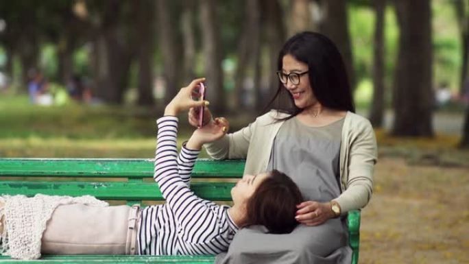 十几岁的女儿在公园的大腿妈妈上睡觉