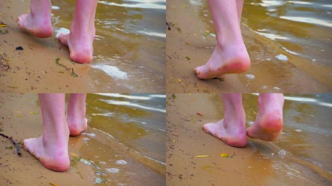 沙滩上的赤脚沿着海岸线走