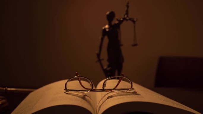 正义的悍马和法律书籍上的女性正义雕塑