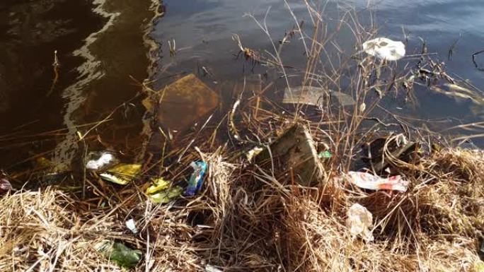 塑料瓶和垃圾漂浮在水中的河岸上。水污染。河流的污染。