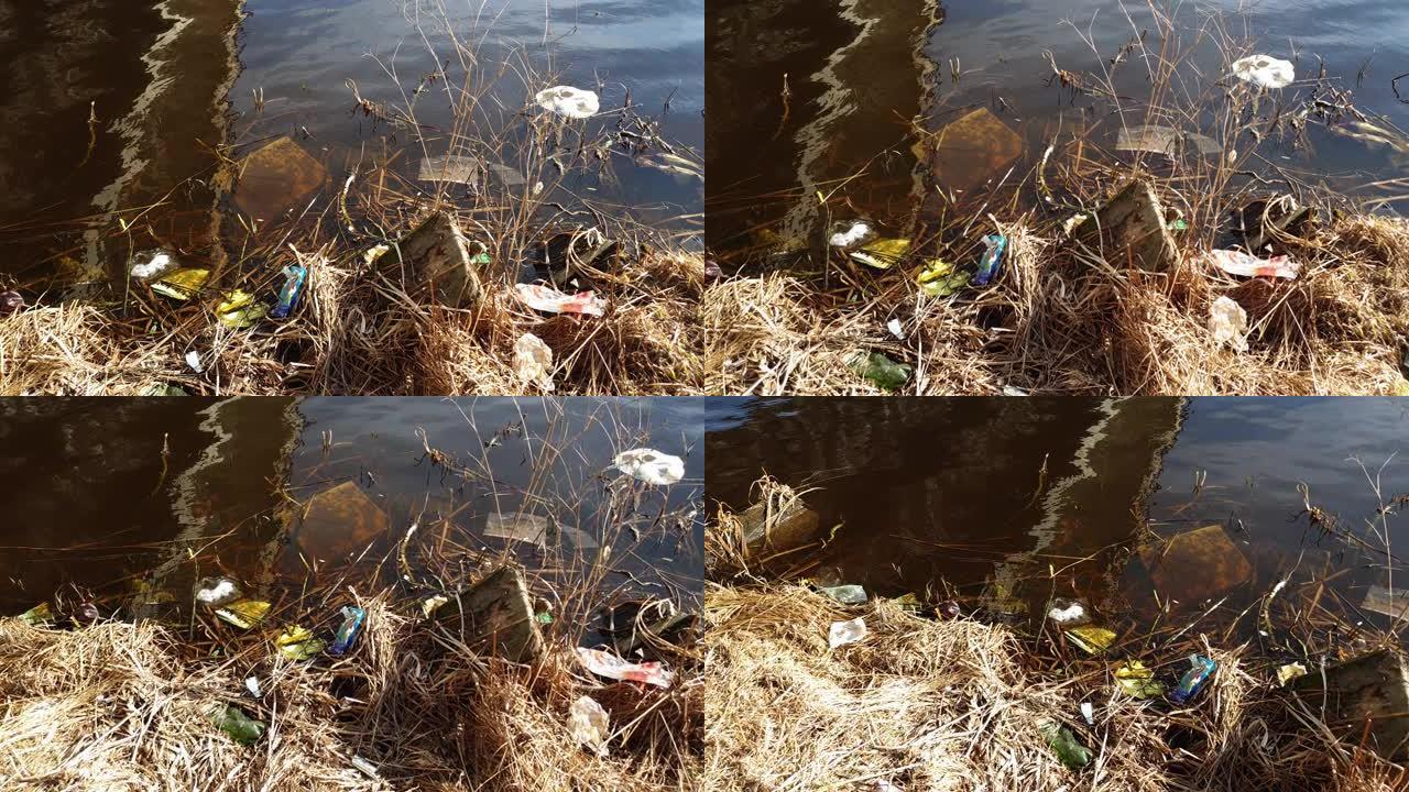 塑料瓶和垃圾漂浮在水中的河岸上。水污染。河流的污染。