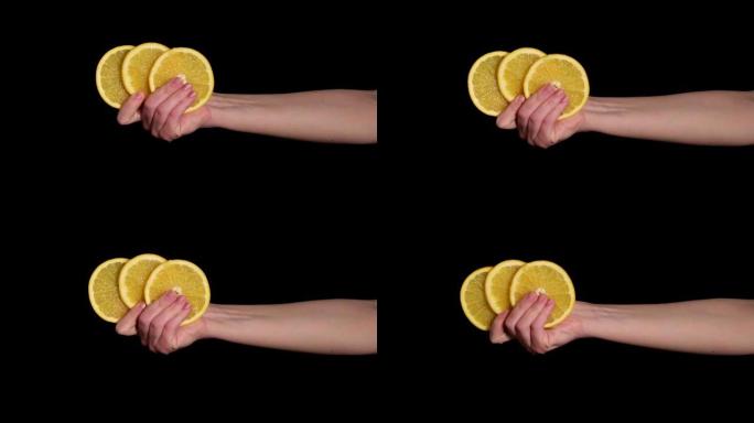 一个女人的手握着三片成熟的鲜橙。4k视频。
