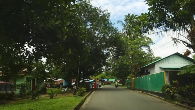 印度尼西亚巴厘岛路边卖食物的街头小贩 路中间有一座清真寺 一个男人站在栅栏前，上面挂着衣服