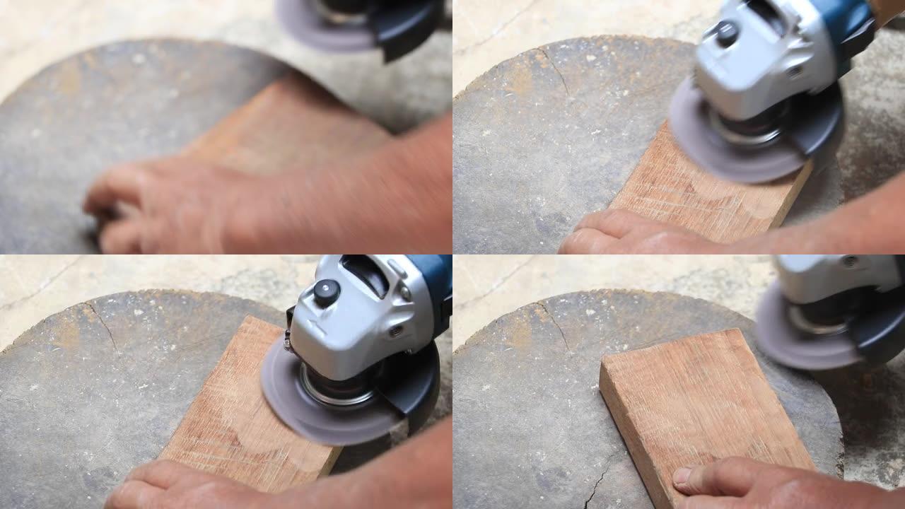老工人手木匠的特写镜头等于在车间用随机轨道砂光机抛光木板，用电动工具打磨老式木制。