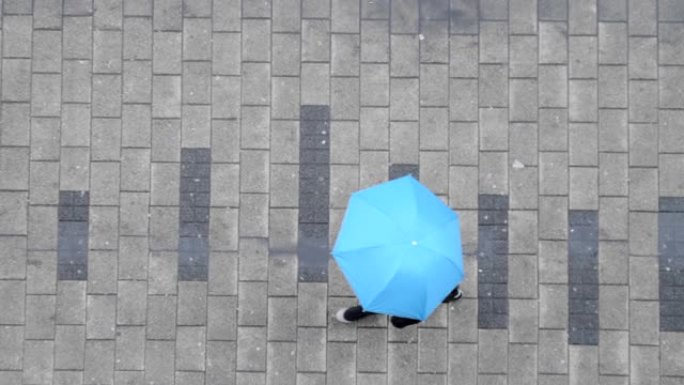 带伞走在街上的人的俯视图。雨天概念。