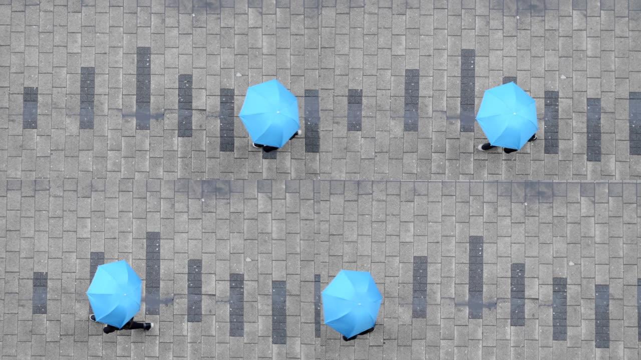 带伞走在街上的人的俯视图。雨天概念。