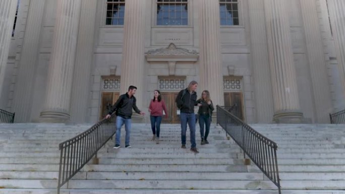 四名大学生从图书馆走下台阶
