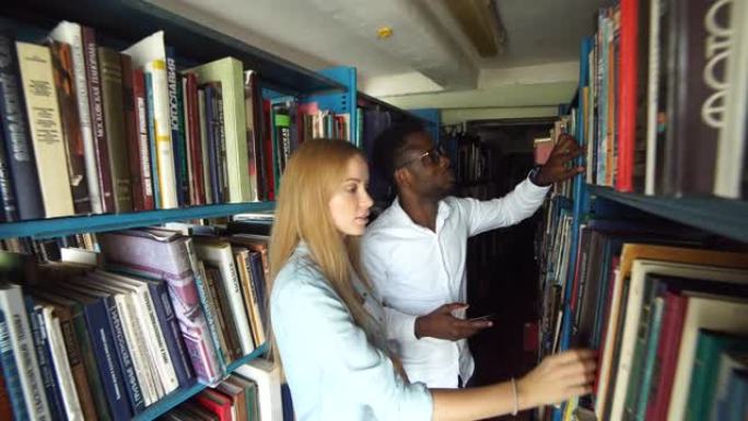 两名年轻的高加索女学生在图书馆选书