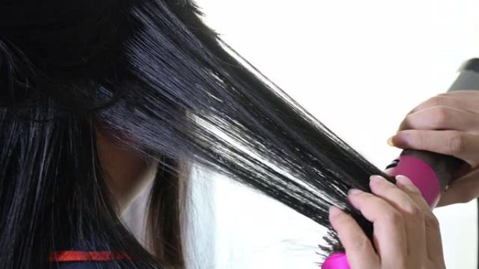 美容师在美容院使用卷发器设置时尚发型