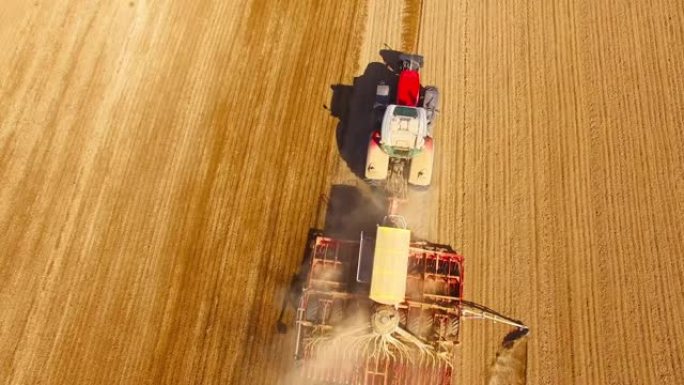 用播种机在田间作业的拖拉机的鸟瞰图。农业从上面看。